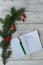 Christmas vertical composition. Branches spruce with red berries and a notebook with plans for the future