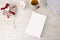 Christmas view from top for a book presentation: book with blank cover with a white lit candles, Christmas decorated cup of tea