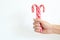 Christmas, winter concept. Holidays, sweets, treats. Man hands holding traditional striped candy cane in shape of bouquet. Male ha