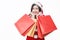 Christmas winter shopping. Asian woman in santa claus hat standing holding shopping bags