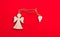 Christmas wooden angel with heart and twine on bright red background. Minimalism concept.