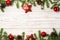 Christmas wooden background with fir branches, pine cones, snow and decorations