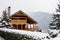 Christmas wooden mansion in mountains on snowfall winter day. Cozy chalet on ski resort near pine forest. Cottage of