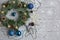 Christmas wreath, beads, blue Christmas toys, snowflakes on a light wooden background