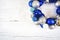 Christmas wreath of blue and white balls on wooden white surface.