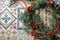 Christmas wreath of evergreen and nandian network berries on retro tiles