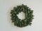 Christmas wreath of fir branches on mint color wall, cozy home, scandinavian design