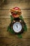Christmas Wreath Fir Tree Branches Vintage Alarm Clock Red Glossy Apple Cinnamon Sticks Anise Star on Weathered Wood Background.