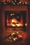 Christmas wreath, glass of champagne, blurred background burning fireplace with fire. Warm cozy Xmas or new year holiday evening