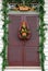 A Christmas wreath hangs on a shuttered front door