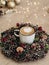 Christmas wreath for home decoration. in the center is a mug with cappuccino coffee.