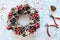 Christmas Wreath Made of branches decorated with gold wooden stars and red berry bubbles. Creative diy craft hobby. Making