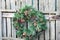 Christmas Wreath with Pinecones Hanging on Fence