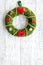 Christmas wreath traditional, classic type. Wreath made of spruce branches and red ribbons on white wooden background