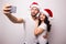 Christmas young beautiful couple in Santa hats in love taking romantic self portrait