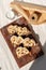 Christstollen, stollen sliced on pieces on wooden board, cup with milk on beige table background with sunlight shadow