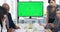 Chroma key blank green screen and copyspace of a monitor with tracking markers in an office business meeting. Busy