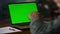 Chroma key computer closeup. Old man having video call at green screen laptop