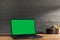 Chroma key green screen, angled view laptop on table