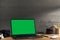 Chroma key green screen, angled view laptop on table with film camera and film rolls