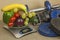 Chrome dumbbells surrounded with healthy fruits and vegetables on a table. Concept of healthy eating and weight loss.