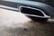 Chrome exhaust pipe of powerful luxury car selective focus with black bodywork as part of exhaust system car muffler of