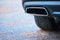 Chrome exhaust pipe selective focus of powerful luxury car with black bodywork as part of exhaust system car muffler of