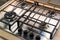 Chrome plate of gas cooker. Four control knobs. Kitchenware.