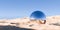 Chrome retro sphere or ball object in surreal abstract desert landscape with blue sky background, geometric primitive fantasy