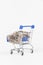 Chrome shiny shopping trolley on wheels with nickel plated coins isolated on white background. close-up
