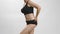 Chubby body positive caucasian girl in black underwear touches, shows and appreciates her body. White studio background