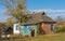 Chubby Caucasian senior standing near his old house and smiling at sunny autumnal day lin Pidstavky village,