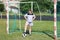 Chubby girl stands in football gate and presses ball with her foot