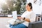 Chubby latin girl working on computer sitting on terrace in Latin America