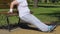 Chubby woman doing crunches leaning on bench in park, tiresome training program