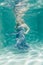 Chubby woman in grey evening long dress swimming underwater on her holidays and enjoy with relax