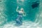 Chubby woman in grey evening long dress swimming underwater on her holidays and enjoy with relax