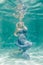 Chubby woman in grey evening long dress swimming underwater on her holidays and enjoy with relax