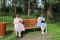 Chubby young girls are sitting on a park bench at a social distance