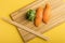 Chukka gunkan seaweed rolls and salmon sushi on a bamboo packing board. Yellow background