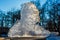 Chunk of ice in frozen lake forest in the background