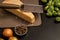 A chunk of parmesan cheese with a grater on a brown board. Nearby are onions, broccoli, black pepper. B