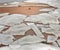 Chunks of ice, ice floes lying on the sand of the beach and a pi