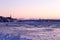 Chunks of ice on the St. Lawrence River with church on northern coast and buildings on the south coast in soft focus background