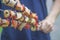 Chunks of meat, tomato and eggplant strung on skewers in the hands