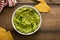 Chunky homemade guacamole in a bowl with tortilla chips