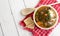 Chunky Italian wedding soup on a light wood background table