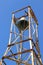 Church bell and rusty bell tower in a blue sky background