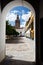 Church bell tower framed by white entrance to road