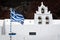 Church with bell tower and Greek flag near Red beach, Santorini